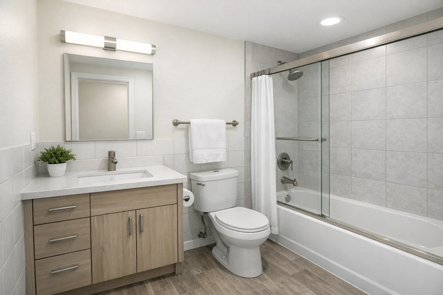 Budget friendly bathroom remodel in Arlington CA with vanity, tub shower combo and tile wall design